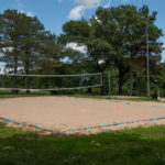 Sand volleyball court with lights for night time play.