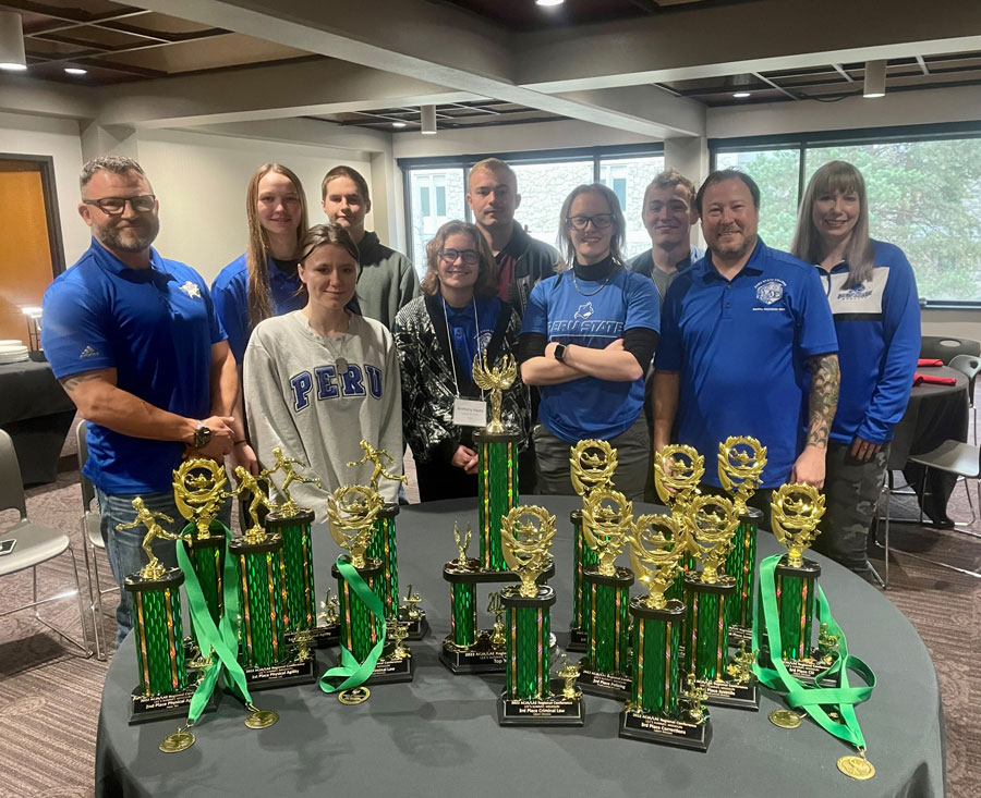 Criminal justice students behind table with awards.