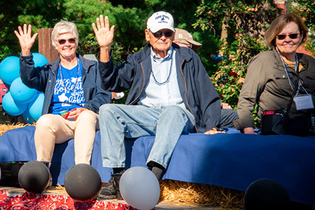 Alums riding on a float during the 首页coming Parade.