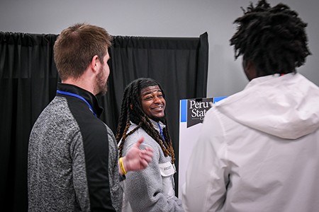 3 students at a poster display.